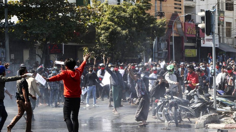 Protesters regroup after police fired warning-shots and used a water cannon to disperse them during a protest in Mandalay, Myanmar on Tuesday, Feb. 9, 2021. Police cracked down Tuesday on the demonstrators protesting against Myanmar’s military takeover who took to the streets in defiance of new protest bans. (AP Photo)