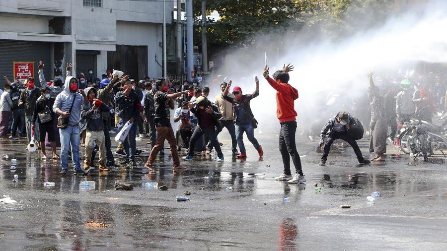 Protesters regroup after police fired warning-shots and used a water cannon to disperse them during a protest in Mandalay, Myanmar on Tuesday, Feb. 9, 2021. Police cracked down Tuesday on the demonstrators protesting against Myanmar’s military takeover who took to the streets in defiance of new protest bans. (AP Photo)