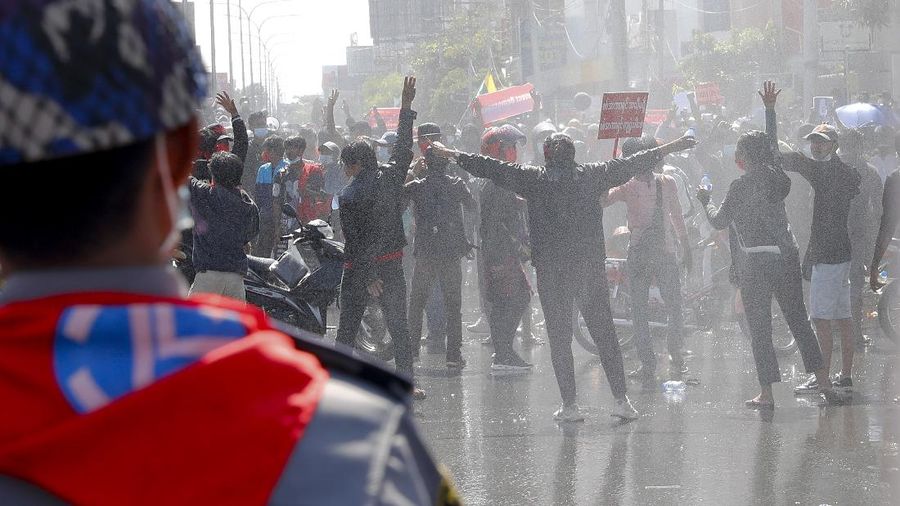 Protesters regroup after police fired warning-shots and used a water cannon to disperse them during a protest in Mandalay, Myanmar on Tuesday, Feb. 9, 2021. Police cracked down Tuesday on the demonstrators protesting against Myanmar’s military takeover who took to the streets in defiance of new protest bans. (AP Photo)