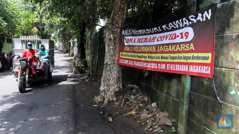Warga melintas di wilayah Zona Merah di Kawasan Jagakarsa, Jakarta Selatan, Selasa (9/2/2021). Aturan mengenai PPKM Mikro yang berlaku mulai 9 Februari 2021 telah diterbitkan lewat Inmendagri 3 Tahun 2021. (CNBC Indonesia/Andrean Kristianto)