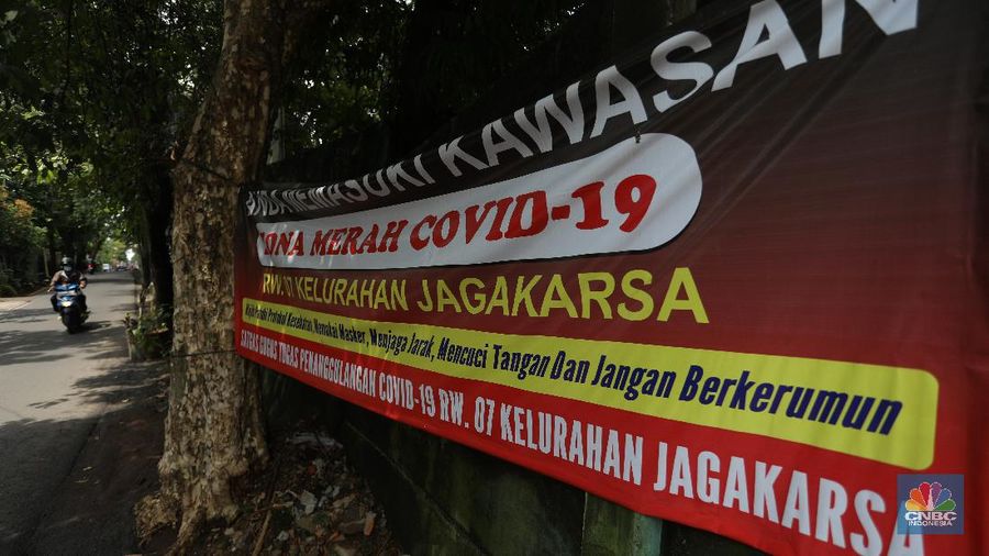 Warga melintas di wilayah Zona Merah di Kawasan Jagakarsa, Jakarta Selatan, Selasa (9/2/2021). Aturan mengenai PPKM Mikro yang berlaku mulai 9 Februari 2021 telah diterbitkan lewat Inmendagri 3 Tahun 2021. (CNBC Indonesia/Andrean Kristianto)