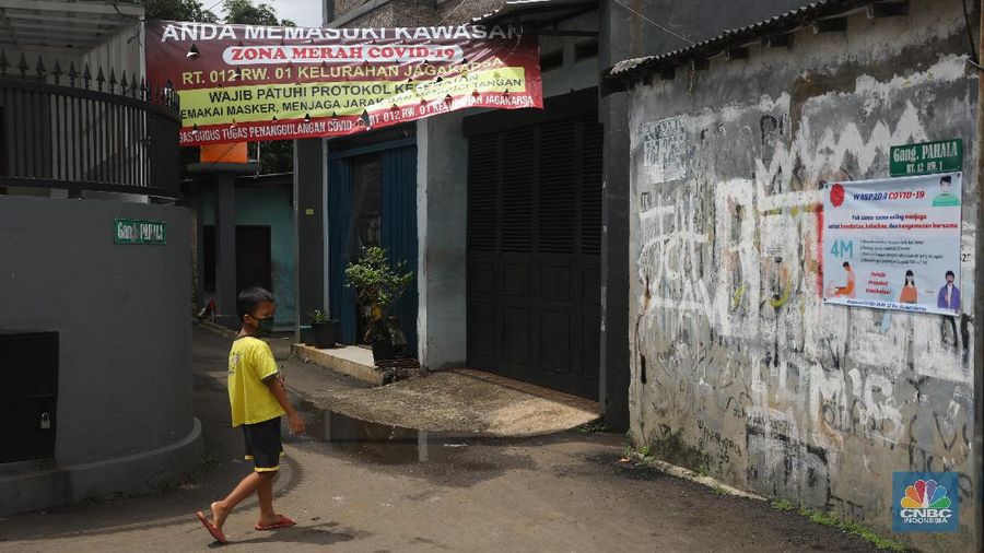 Warga melintas di wilayah Zona Merah di Kawasan Jagakarsa, Jakarta Selatan, Selasa (9/2/2021). Aturan mengenai PPKM Mikro yang berlaku mulai 9 Februari 2021 telah diterbitkan lewat Inmendagri 3 Tahun 2021. (CNBC Indonesia/Andrean Kristianto)