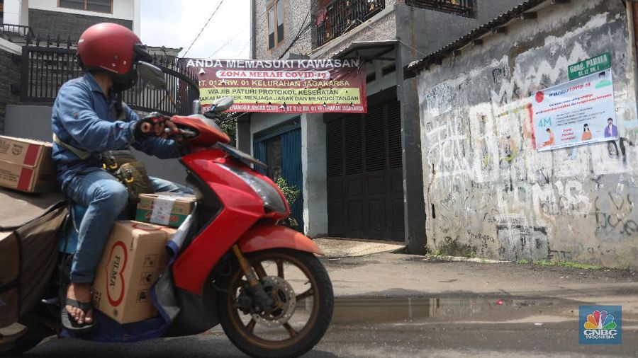 Warga melintas di wilayah Zona Merah di Kawasan Jagakarsa, Jakarta Selatan, Selasa (9/2/2021). Aturan mengenai PPKM Mikro yang berlaku mulai 9 Februari 2021 telah diterbitkan lewat Inmendagri 3 Tahun 2021. (CNBC Indonesia/Andrean Kristianto)