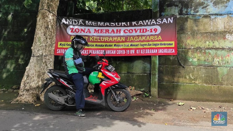 Warga melintas di wilayah Zona Merah di Kawasan Jagakarsa, Jakarta Selatan, Selasa (9/2/2021). Aturan mengenai PPKM Mikro yang berlaku mulai 9 Februari 2021 telah diterbitkan lewat Inmendagri 3 Tahun 2021. (CNBC Indonesia/Andrean Kristianto)
