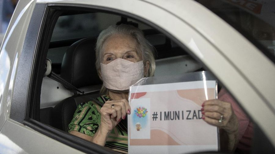 Health workers guide drivers to shots of China's Sinovac CoronaVac vaccine during a priority COVID-19 vaccination program for the elderly at a drive-thru set up in the Pacaembu soccer stadium parking lot in Sao Paulo, Brazil, Monday, Feb. 8, 2021. (AP Photo/Andre Penner)