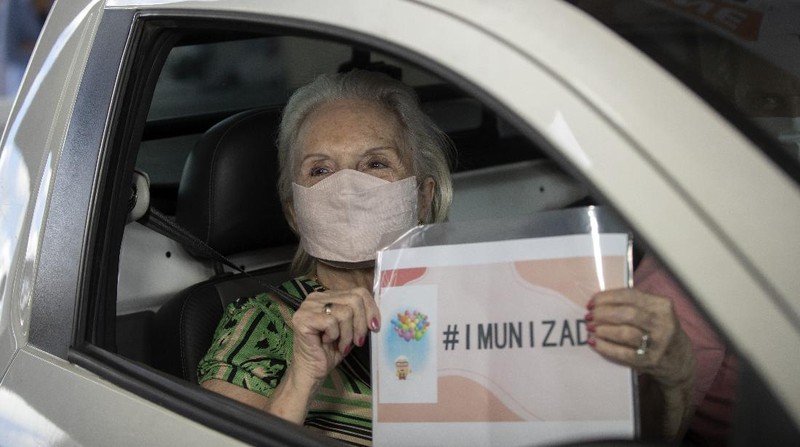 Health workers guide drivers to shots of China's Sinovac CoronaVac vaccine during a priority COVID-19 vaccination program for the elderly at a drive-thru set up in the Pacaembu soccer stadium parking lot in Sao Paulo, Brazil, Monday, Feb. 8, 2021. (AP Photo/Andre Penner)