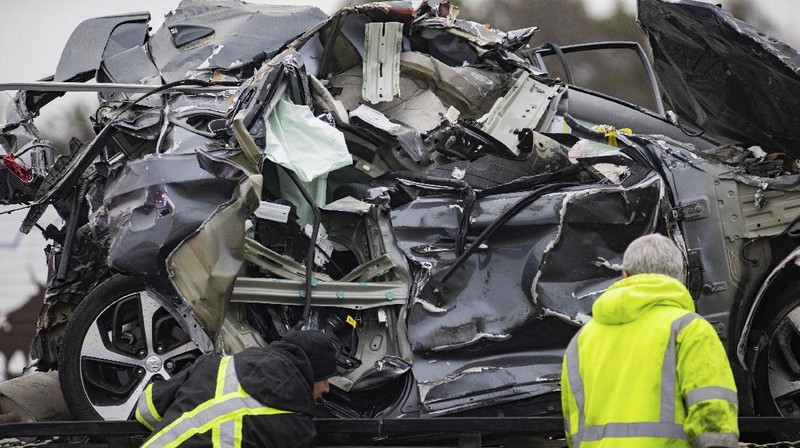 A crumbled car is towed as emergency crews work to clear the pile-up on Interstate 35 in Fort Worth, Texas on Thursday, Feb. 11, 2021. A massive crash involving more than 130 vehicles on the icy Texas interstate left at least six people dead and dozens injured amid a winter storm that dropped freezing rain, sleet and snow on parts of the U.S. (Juan Figueroa/The Dallas Morning News via AP)
