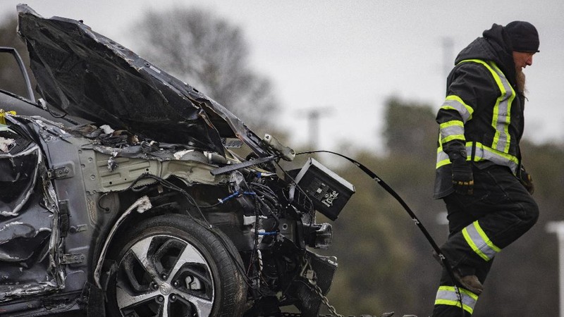 A crumbled car is towed as emergency crews work to clear the pile-up on Interstate 35 in Fort Worth, Texas on Thursday, Feb. 11, 2021. A massive crash involving more than 130 vehicles on the icy Texas interstate left at least six people dead and dozens injured amid a winter storm that dropped freezing rain, sleet and snow on parts of the U.S. (Juan Figueroa/The Dallas Morning News via AP)