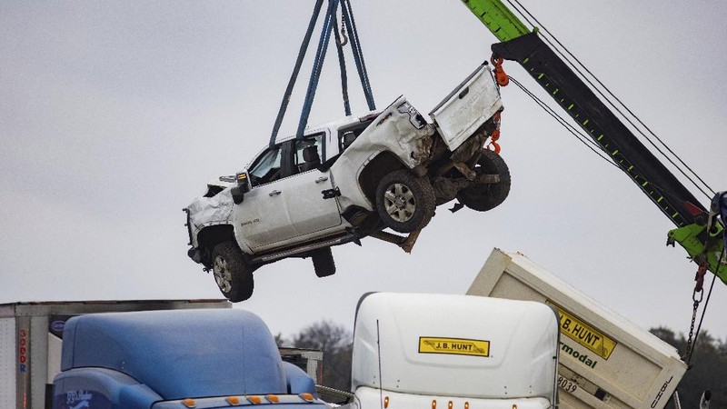 A crumbled car is towed as emergency crews work to clear the pile-up on Interstate 35 in Fort Worth, Texas on Thursday, Feb. 11, 2021. A massive crash involving more than 130 vehicles on the icy Texas interstate left at least six people dead and dozens injured amid a winter storm that dropped freezing rain, sleet and snow on parts of the U.S. (Juan Figueroa/The Dallas Morning News via AP)