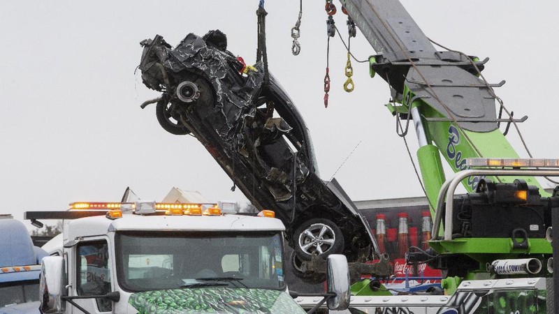 A crumbled car is towed as emergency crews work to clear the pile-up on Interstate 35 in Fort Worth, Texas on Thursday, Feb. 11, 2021. A massive crash involving more than 130 vehicles on the icy Texas interstate left at least six people dead and dozens injured amid a winter storm that dropped freezing rain, sleet and snow on parts of the U.S. (Juan Figueroa/The Dallas Morning News via AP)