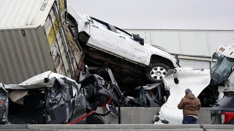 A crumbled car is towed as emergency crews work to clear the pile-up on Interstate 35 in Fort Worth, Texas on Thursday, Feb. 11, 2021. A massive crash involving more than 130 vehicles on the icy Texas interstate left at least six people dead and dozens injured amid a winter storm that dropped freezing rain, sleet and snow on parts of the U.S. (Juan Figueroa/The Dallas Morning News via AP)