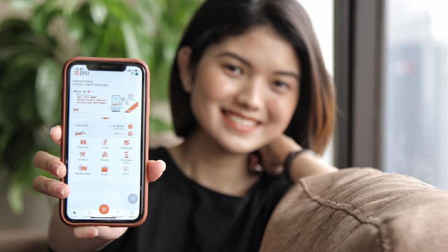 Nasabah milenial menunjukkan aplikasi BNI Mobile Banking pada smartphone. (Dok. BNI)