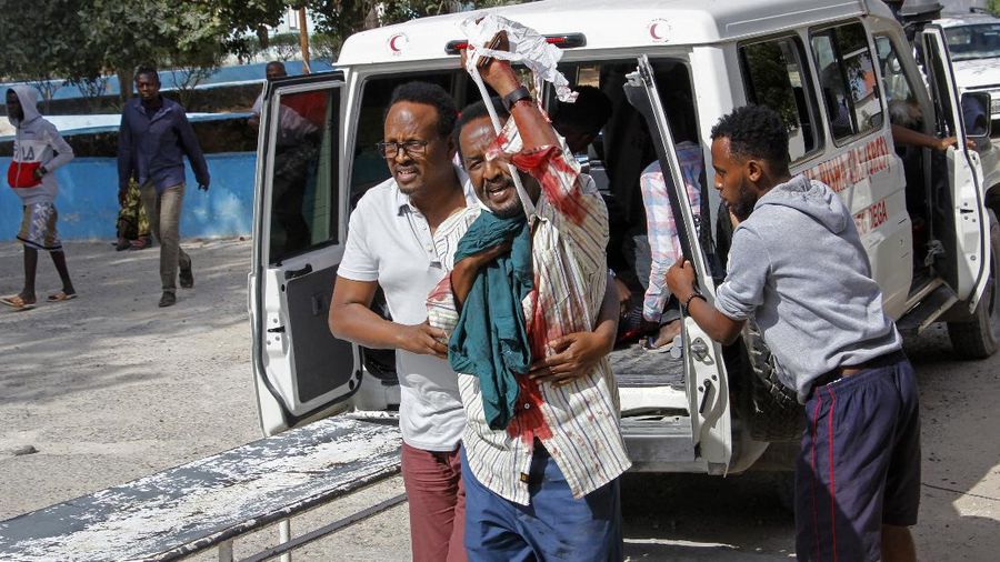 Rescuers at the scene of a bombing in Mogadishu, Somalia Saturday, Feb. 13, 2021. Police say a suicide bomber died and a number of civilians were wounded when a vehicle exploded near a checkpoint outside the presidential palace in Somalia's capital, Mogadishu. (AP Photo/Farah Abdi Warsameh)