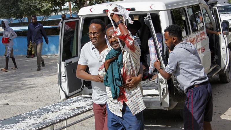 Rescuers at the scene of a bombing in Mogadishu, Somalia Saturday, Feb. 13, 2021. Police say a suicide bomber died and a number of civilians were wounded when a vehicle exploded near a checkpoint outside the presidential palace in Somalia's capital, Mogadishu. (AP Photo/Farah Abdi Warsameh)