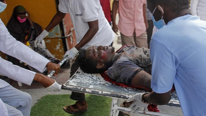 Rescuers at the scene of a bombing in Mogadishu, Somalia Saturday, Feb. 13, 2021. Police say a suicide bomber died and a number of civilians were wounded when a vehicle exploded near a checkpoint outside the presidential palace in Somalia's capital, Mogadishu. (AP Photo/Farah Abdi Warsameh)