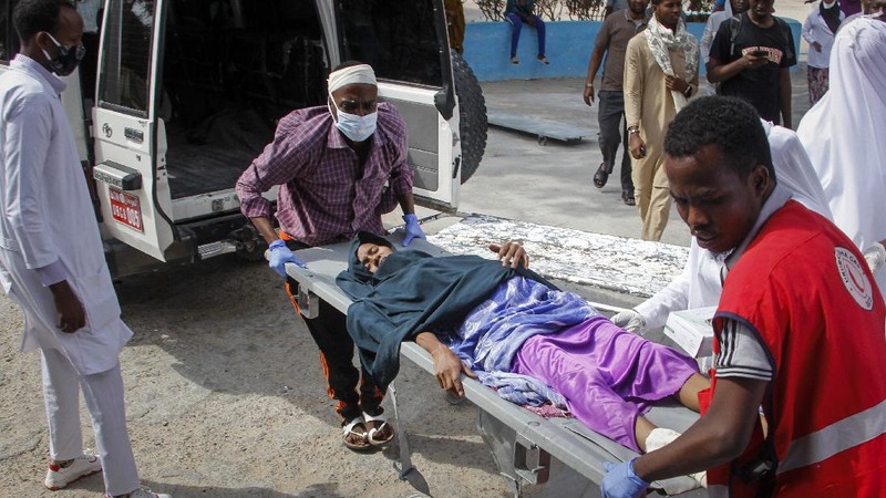 Rescuers at the scene of a bombing in Mogadishu, Somalia Saturday, Feb. 13, 2021. Police say a suicide bomber died and a number of civilians were wounded when a vehicle exploded near a checkpoint outside the presidential palace in Somalia's capital, Mogadishu. (AP Photo/Farah Abdi Warsameh)