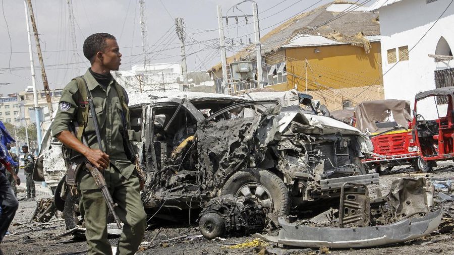 Rescuers at the scene of a bombing in Mogadishu, Somalia Saturday, Feb. 13, 2021. Police say a suicide bomber died and a number of civilians were wounded when a vehicle exploded near a checkpoint outside the presidential palace in Somalia's capital, Mogadishu. (AP Photo/Farah Abdi Warsameh)