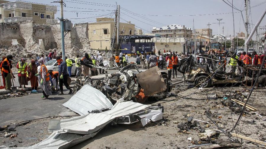 Rescuers at the scene of a bombing in Mogadishu, Somalia Saturday, Feb. 13, 2021. Police say a suicide bomber died and a number of civilians were wounded when a vehicle exploded near a checkpoint outside the presidential palace in Somalia's capital, Mogadishu. (AP Photo/Farah Abdi Warsameh)