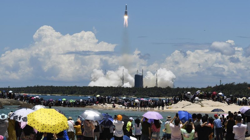 In this July 23, 2020, file photo released by China's Xinhua News Agency, spectators watch as a Long March-5 rocket carrying the Tianwen-1 Mars probe lifts off from the Wenchang Space Launch Center in southern China's Hainan Province. China is falling in love with space, inspired by the ruling Communist Party's increasingly ambitious missions over the past two decades to fire humans into orbit and explore the moon and Mars. (Yang Guanyu/Xinhua via AP, File)