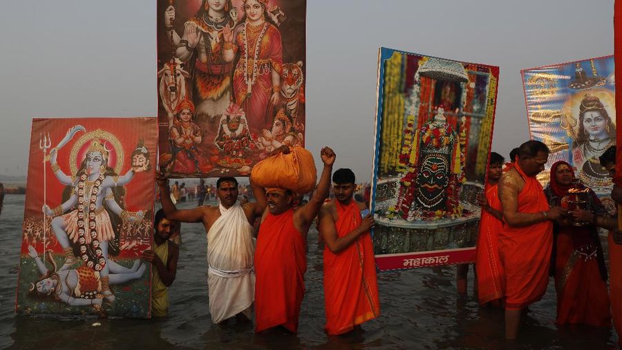 Devotees carry images of Hindu deities as they gather to take holy dips at Sangam, the confluence of the rivers Ganges and the Yamuna on 'Mauni Amavasya' or new moon day, an auspicious bathing day during the annual month long Hindu religious fair 
