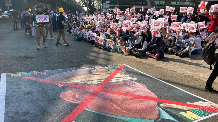 APTOPIX Myanmar A large image that has an X mark on the face of Commander in chief Senior Gen. Min Aung Hlaing, also chairman of the State Administrative Council, lies on a road as anti-coup protesters gather outside the Hledan Centre in Yangon, Myanmar, Sunday, Feb. 14, 2021. Daily mass street demonstrations in Myanmar are on their second week, with neither protesters nor the military government they seek to unseat showing any signs of backing down from confrontations. (AP Photo)