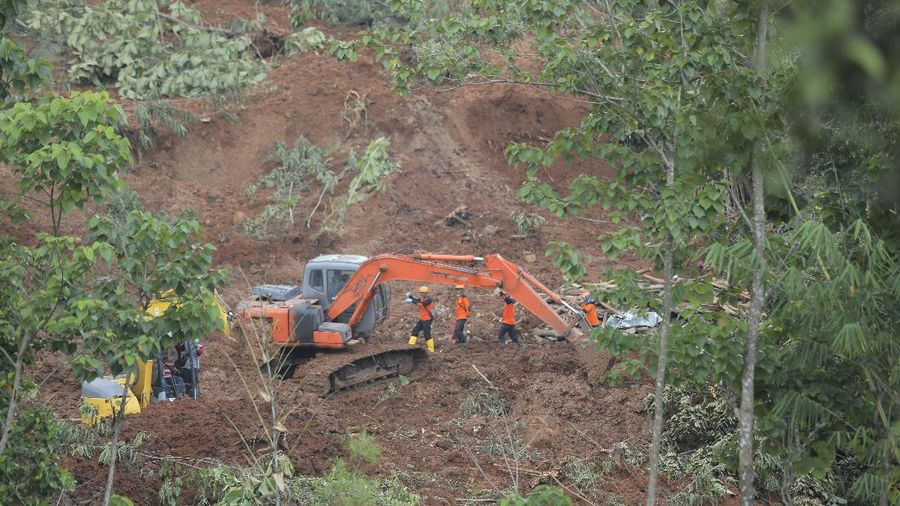 Rescuers search for victims at a village hit by a landslide in Nganjuk, East Java, Indonesia, Monday, Feb. 15, 2021. Torrential rains triggered a landslide on Indonesia's main island of Java, leaving a number of people killed or missing, as emergency personnel digging with their bare hands and farm tools desperately sought to unearth more victims on Monday, officials said. (AP Photo/Trisnadi)