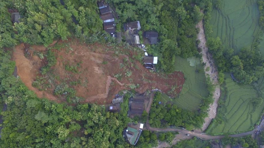 Rescuers search for victims at a village hit by a landslide in Nganjuk, East Java, Indonesia, Monday, Feb. 15, 2021. Torrential rains triggered a landslide on Indonesia's main island of Java, leaving a number of people killed or missing, as emergency personnel digging with their bare hands and farm tools desperately sought to unearth more victims on Monday, officials said. (AP Photo/Trisnadi)