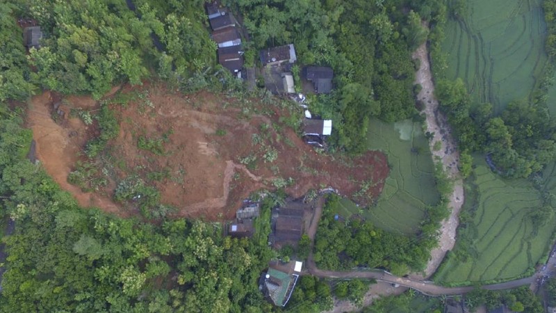 Rescuers search for victims at a village hit by a landslide in Nganjuk, East Java, Indonesia, Monday, Feb. 15, 2021. Torrential rains triggered a landslide on Indonesia's main island of Java, leaving a number of people killed or missing, as emergency personnel digging with their bare hands and farm tools desperately sought to unearth more victims on Monday, officials said. (AP Photo/Trisnadi)