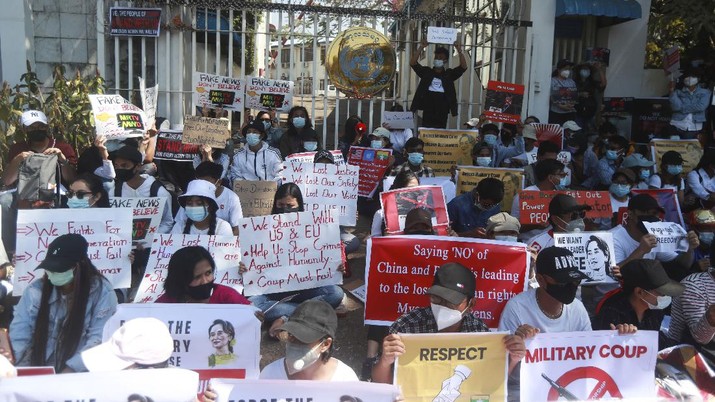 Myanmar Anti-coup protesters hold posters as they gather outside the U.N. Information Office in Yangon, Myanmar, Sunday, Feb. 14, 2021. Vast numbers of people all over Myanmar have flouted orders against demonstrations to march again in protest against the military takeover that ousted the elected government of Suu Kyi. (AP Photo)