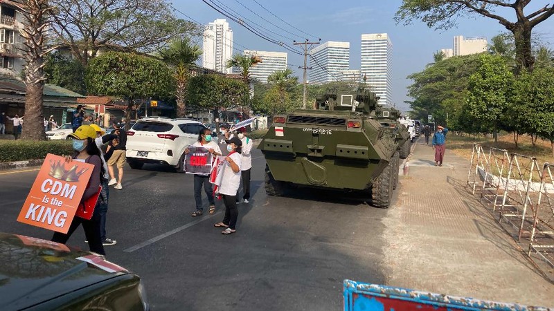 Anti-coup protesters stand in front of an armored personnel carrier deployed outside the Central Bank building in Yangon, Myanmar Monday, Feb. 15, 2021. Sightings of armored personnel carriers in Myanmar's biggest city and an internet shutdown raised political tensions late Sunday, after vast numbers of people around the country flouted orders against demonstrations to protest the military's seizure of power. (AP Photo)