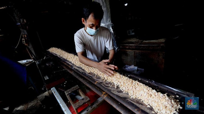Perajin memproduksi tempe di salah satu pabrik rumahan di Jakarta, Senin (15/2/2021). Harga biji kedelai terus menguat di tengah penurunan ekspor dari Amerika Serikat dan sentimen proyeksi kenaikan pasokan dari negara produsen. (CNBC Indonesia/Tri Susilo)