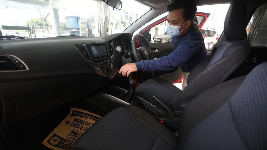 Calon pembeli melihat mobil baru di Showroom Suzuki di Kawasan Gading Serpong, Tangerang Selatan, Selasa (16/2/2021). Pemerintah memutuskan untuk memberikan insentif Pajak Penjualan Barang Mewah (PPnBM) atau pajak 0%. Insentif tersebut terbagi menjadi tiga tahap yang akan dievaluasi per tiga bulan. (CNBC Indonesia/Andrean Kristianto)