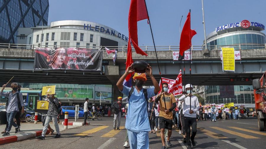 A demonstrator displays an upside-down begging-bowl, a form of protest symbolizing the refusal to receive any kind of alms from the military government during a protest against the military coup in Yangon, Myanmar Tuesday, Feb. 16, 2021. Security forces in Myanmar pointed guns toward anti-coup protesters and attacked them with sticks Monday, seeking to quell the large-scale demonstrations calling for the military junta that seized power this month to reinstate the elected government. (AP Photo)