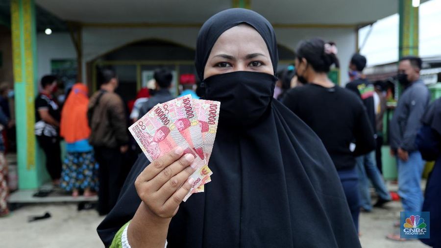 Warga menerima Bantuan Langsung Tunai (BLT) di Sawangan, Depok, Selasa (16/2/2021). Pemerintah melalui Kementerian Sosial (Kemensos) tahun ini melanjutkan penyaluran program Bantuan Sosial Tunai atau bantuan langsung tunai (BLT) secara bertahap melalui Kantor Pos. (CNBC Indonesia/Tri Susilo)
