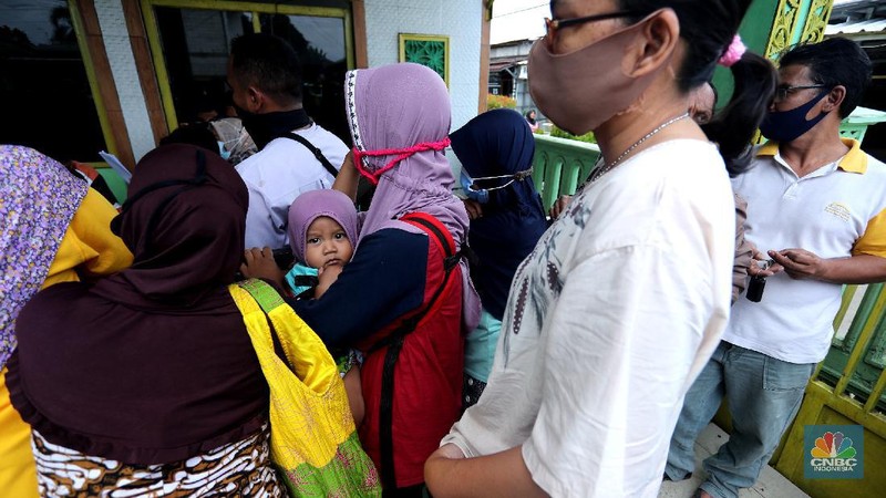 Warga menerima Bantuan Langsung Tunai (BLT) di Sawangan, Depok, Selasa (16/2/2021). Pemerintah melalui Kementerian Sosial (Kemensos) tahun ini melanjutkan penyaluran program Bantuan Sosial Tunai atau bantuan langsung tunai (BLT) secara bertahap melalui Kantor Pos. (CNBC Indonesia/Tri Susilo)