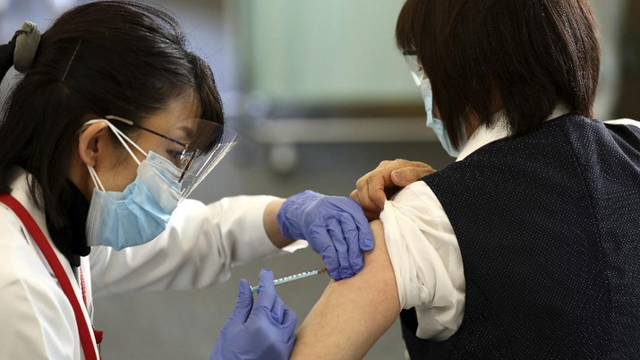 Virus Outbreak Japan Vaccine A medical worker checks the form of his colleague before giving her a dose of the COVID-19 vaccine at Tokyo Medical Center in Tokyo Wednesday, Feb. 17, 2021. Japan's first coronavirus shots were given to health workers Wednesday, beginning a vaccination campaign considered crucial to holding the already delayed Tokyo Olympics. (Behrouz Mehri/Pool Photo via AP)