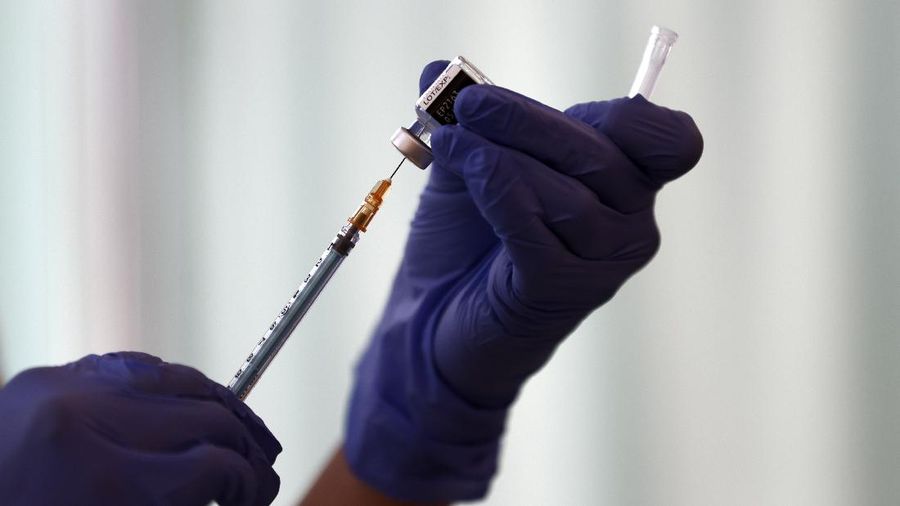 A medical worker checks the form of his colleague before giving her a dose of the COVID-19 vaccine at Tokyo Medical Center in Tokyo Wednesday, Feb. 17, 2021. Japan's first coronavirus shots were given to health workers Wednesday, beginning a vaccination campaign considered crucial to holding the already delayed Tokyo Olympics. (Behrouz Mehri/Pool Photo via AP)