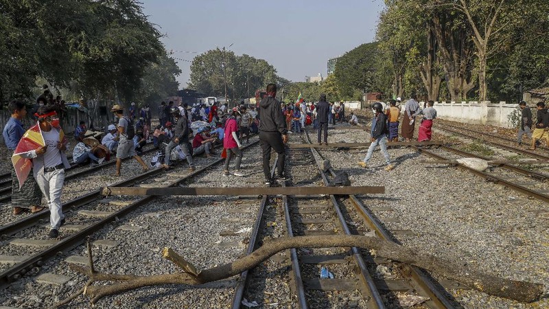 Demonstrators with placards lie on the railway tracks in an attempt to disrupt train service during a protest against the military coup in Mandalay, Myanmar on Wednesday, Feb. 17, 2021. Demonstrators in Myanmar gathered Wednesday in their largest numbers so far to protest the military’s seizure of power, even after a U.N. human rights expert warned that troops being brought to Yangon and elsewhere could signal the prospect of major violence. (AP Photo)