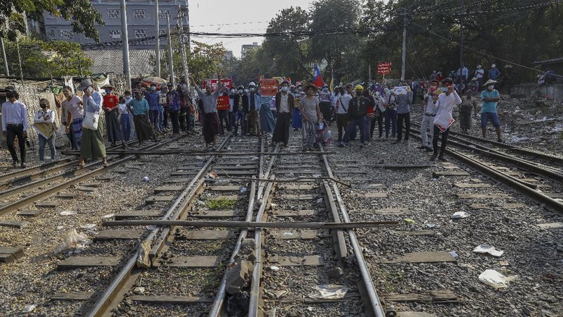 Demonstrators with placards lie on the railway tracks in an attempt to disrupt train service during a protest against the military coup in Mandalay, Myanmar on Wednesday, Feb. 17, 2021. Demonstrators in Myanmar gathered Wednesday in their largest numbers so far to protest the military’s seizure of power, even after a U.N. human rights expert warned that troops being brought to Yangon and elsewhere could signal the prospect of major violence. (AP Photo)