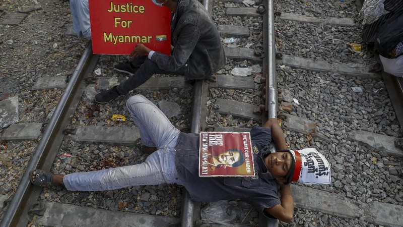 Demonstrators with placards lie on the railway tracks in an attempt to disrupt train service during a protest against the military coup in Mandalay, Myanmar on Wednesday, Feb. 17, 2021. Demonstrators in Myanmar gathered Wednesday in their largest numbers so far to protest the military’s seizure of power, even after a U.N. human rights expert warned that troops being brought to Yangon and elsewhere could signal the prospect of major violence. (AP Photo)