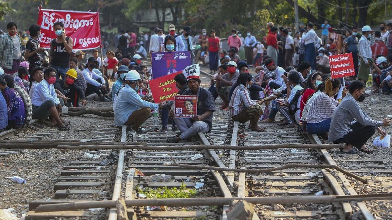 Demonstrators with placards lie on the railway tracks in an attempt to disrupt train service during a protest against the military coup in Mandalay, Myanmar on Wednesday, Feb. 17, 2021. Demonstrators in Myanmar gathered Wednesday in their largest numbers so far to protest the military’s seizure of power, even after a U.N. human rights expert warned that troops being brought to Yangon and elsewhere could signal the prospect of major violence. (AP Photo)