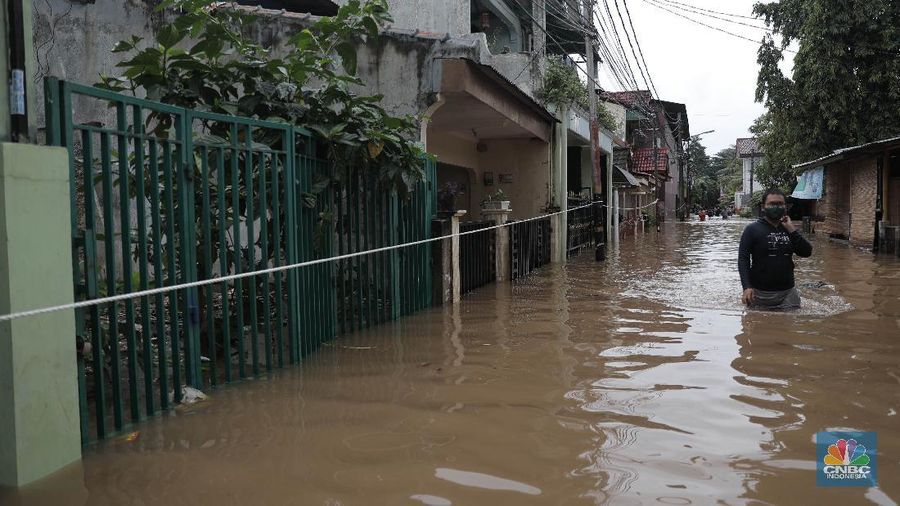Aktivitas warga di pemukiman yang terendam air di Kawasan Cipinang Melayu, Jakarta, Jumat, 19/2. Banjir sekitar 1 meter merendam permukiman warga Cipinang Melayu Jakarta timur. Warga setempat mengungsi ke sejumlah tempat seperti pelataran parkir Universitas Borobudur. Menurut warga setempat kawasan RW 04 Cipinang Melayu kembali dilanda banjir sejak 03.30 WIB dini hari. Dia mengatakan jika banjir yang terjadi di daerahnya, karena luapan kali sunter akibat intensitas hujan yang tinggi. Sementara itu mesin pompa sudah disiapkan oleh pemadam kebakaran untuk menyedot air.(CNBC Indonesia/ Muhammad Sabki)