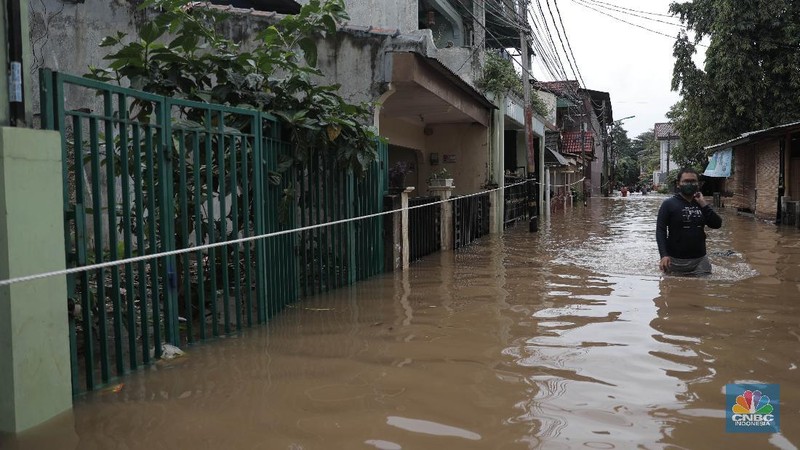 Aktivitas warga di pemukiman yang terendam air di Kawasan Cipinang Melayu, Jakarta, Jumat, 19/2. Banjir sekitar 1 meter merendam permukiman warga Cipinang Melayu Jakarta timur. Warga setempat mengungsi ke sejumlah tempat seperti pelataran parkir Universitas Borobudur. Menurut warga setempat kawasan RW 04 Cipinang Melayu kembali dilanda banjir sejak 03.30 WIB dini hari. Dia mengatakan jika banjir yang terjadi di daerahnya, karena luapan kali sunter akibat intensitas hujan yang tinggi. Sementara itu mesin pompa sudah disiapkan oleh pemadam kebakaran untuk menyedot air.(CNBC Indonesia/ Muhammad Sabki)