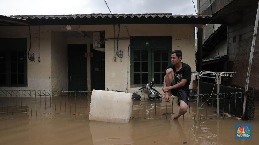 Aktivitas warga di pemukiman yang terendam air di Kawasan Cipinang Melayu, Jakarta, Jumat, 19/2. Banjir sekitar 1 meter merendam permukiman warga Cipinang Melayu Jakarta timur. Warga setempat mengungsi ke sejumlah tempat seperti pelataran parkir Universitas Borobudur. Menurut warga setempat kawasan RW 04 Cipinang Melayu kembali dilanda banjir sejak 03.30 WIB dini hari. Dia mengatakan jika banjir yang terjadi di daerahnya, karena luapan kali sunter akibat intensitas hujan yang tinggi. Sementara itu mesin pompa sudah disiapkan oleh pemadam kebakaran untuk menyedot air.(CNBC Indonesia/ Muhammad Sabki)