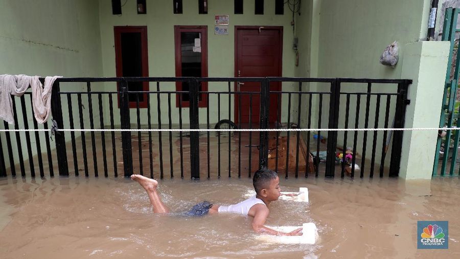 Aktivitas warga di pemukiman yang terendam air di Kawasan Cipinang Melayu, Jakarta, Jumat, 19/2. Banjir sekitar 1 meter merendam permukiman warga Cipinang Melayu Jakarta timur. Warga setempat mengungsi ke sejumlah tempat seperti pelataran parkir Universitas Borobudur. Menurut warga setempat kawasan RW 04 Cipinang Melayu kembali dilanda banjir sejak 03.30 WIB dini hari. Dia mengatakan jika banjir yang terjadi di daerahnya, karena luapan kali sunter akibat intensitas hujan yang tinggi. Sementara itu mesin pompa sudah disiapkan oleh pemadam kebakaran untuk menyedot air.(CNBC Indonesia/ Muhammad Sabki)