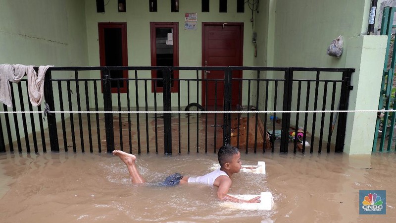 Aktivitas warga di pemukiman yang terendam air di Kawasan Cipinang Melayu, Jakarta, Jumat, 19/2. Banjir sekitar 1 meter merendam permukiman warga Cipinang Melayu Jakarta timur. Warga setempat mengungsi ke sejumlah tempat seperti pelataran parkir Universitas Borobudur. Menurut warga setempat kawasan RW 04 Cipinang Melayu kembali dilanda banjir sejak 03.30 WIB dini hari. Dia mengatakan jika banjir yang terjadi di daerahnya, karena luapan kali sunter akibat intensitas hujan yang tinggi. Sementara itu mesin pompa sudah disiapkan oleh pemadam kebakaran untuk menyedot air.(CNBC Indonesia/ Muhammad Sabki)