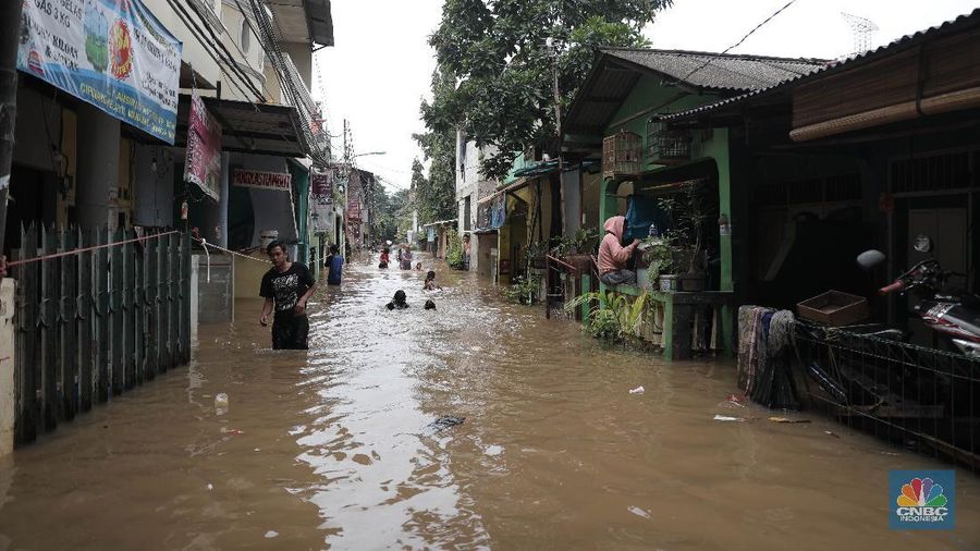 Aktivitas warga di pemukiman yang terendam air di Kawasan Cipinang Melayu, Jakarta, Jumat, 19/2. Banjir sekitar 1 meter merendam permukiman warga Cipinang Melayu Jakarta timur. Warga setempat mengungsi ke sejumlah tempat seperti pelataran parkir Universitas Borobudur. Menurut warga setempat kawasan RW 04 Cipinang Melayu kembali dilanda banjir sejak 03.30 WIB dini hari. Dia mengatakan jika banjir yang terjadi di daerahnya, karena luapan kali sunter akibat intensitas hujan yang tinggi. Sementara itu mesin pompa sudah disiapkan oleh pemadam kebakaran untuk menyedot air.(CNBC Indonesia/ Muhammad Sabki)