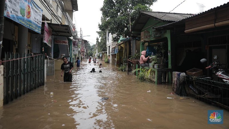Aktivitas warga di pemukiman yang terendam air di Kawasan Cipinang Melayu, Jakarta, Jumat, 19/2. Banjir sekitar 1 meter merendam permukiman warga Cipinang Melayu Jakarta timur. Warga setempat mengungsi ke sejumlah tempat seperti pelataran parkir Universitas Borobudur. Menurut warga setempat kawasan RW 04 Cipinang Melayu kembali dilanda banjir sejak 03.30 WIB dini hari. Dia mengatakan jika banjir yang terjadi di daerahnya, karena luapan kali sunter akibat intensitas hujan yang tinggi. Sementara itu mesin pompa sudah disiapkan oleh pemadam kebakaran untuk menyedot air.(CNBC Indonesia/ Muhammad Sabki)