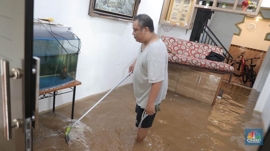Aktivitas warga di pemukiman yang terendam air di Kawasan Cipinang Melayu, Jakarta, Jumat, 19/2. Banjir sekitar 1 meter merendam permukiman warga Cipinang Melayu Jakarta timur. Warga setempat mengungsi ke sejumlah tempat seperti pelataran parkir Universitas Borobudur. Menurut warga setempat kawasan RW 04 Cipinang Melayu kembali dilanda banjir sejak 03.30 WIB dini hari. Dia mengatakan jika banjir yang terjadi di daerahnya, karena luapan kali sunter akibat intensitas hujan yang tinggi. Sementara itu mesin pompa sudah disiapkan oleh pemadam kebakaran untuk menyedot air.(CNBC Indonesia/ Muhammad Sabki)