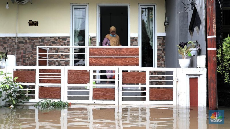 Warga melintas di komplek perumahan yang terendam banjir di Jatibening Permai, Bekasi, Jawa Barat, Jumat 19/2. Hujan yang mengguyur Kota Bekasi menyebabkan banjir di sejumlah titik. Bahkan ketinggian banjir di Perumahan Jatibening Permai mencapai perut orang dewasa. Hingga kini banjir belum juga surut. Peroses evakuasi masih berjalan. Perahu karet disiapkan untuk evakuasi warga yang masih di dalam perumahan. Diketahui terdapat 6 Kecamatan di Kota Bekasi yang tergenang akibat hujan. (վ/ Muhammad Sabki)